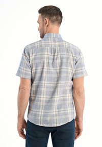 Camicia a maniche corte a quadri in blu chiaro e crema, con colletto button-down e yoke sul retro, realizzata in tessuto leggero. Design casual.