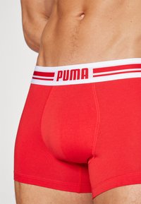 Røde bomull boksershorts med hvit midjebånd som har rødt "PUMA"-logo og stripedesign. Fitted snitt med glatt tekstur.