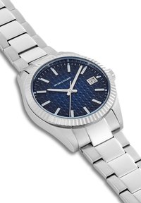 Zilveren roestvrijstalen horloge met een gestructureerde blauwe wijzerplaat, datumaanduiding en zilveren accenten op een schakelarmband.