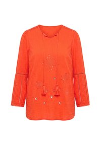 Blouse orange vif à manches longues avec liens à pompons au col en V, tissu texturé, inserts en dentelle sur les manches et broderie florale à sequins sur le devant.
