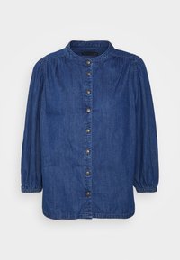 Camicia in denim con maniche lunghe a sbuffo, polsini elasticizzati, colletto rotondo e fila frontale di bottoni marroni.