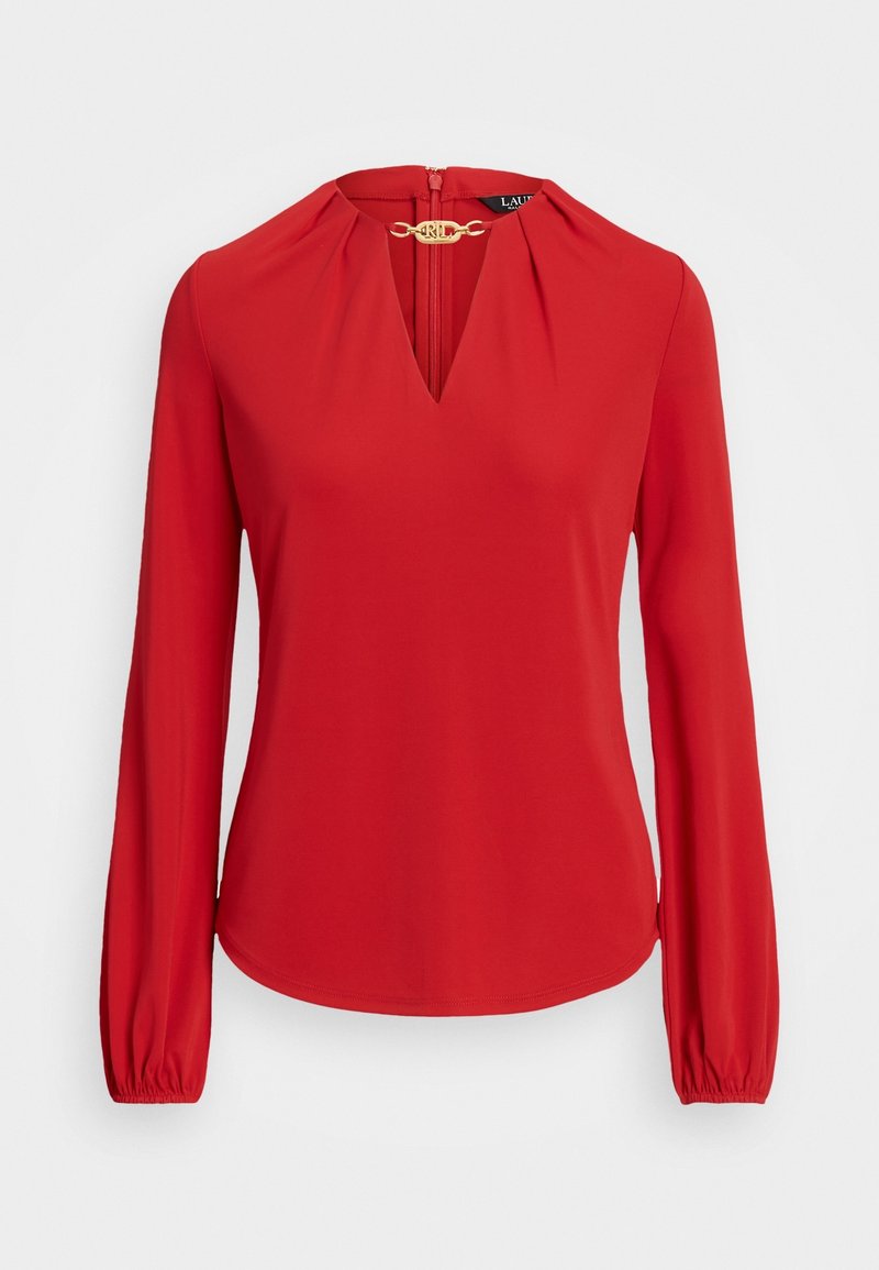 Czerwona bluzka z długim rękawem, z wycięciem w kształcie litery V i ozdobnym złotym zapięciem przy kołnierzu, z marszczonymi detalami i elastycznymi mankietami.