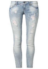 Light blue denim skinny jeans with distressed rips and frayed edges, featuring a standard waistband and five-pocket design.
