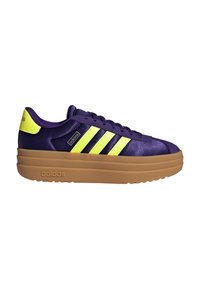 Paarse Adidas sneaker met felgele strepen en hielstuk, dikke lichtbruine platformzool, zijkantlogo en vetersluiting.