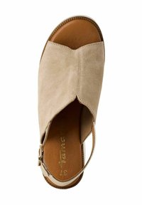 Beige semsket sandal med åben tå og ankelrem. Har en glat brun læder sål og struktureret kant. Guldtonet hardware accent.