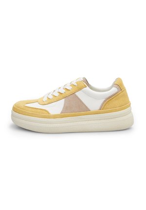 Sneakerit, joissa on valkoinen nahkavarsi, keltaisia ja beigejä mokkahiuksia, paksu kumipohja ja valkoiset nauhat. Rakeinen välikerros gripin parantamiseksi.