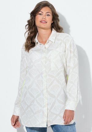 Long-sleeve, button-up shirt in light cream with a leaf pattern. Features a pocket and green accent along the side, made of soft fabric.
