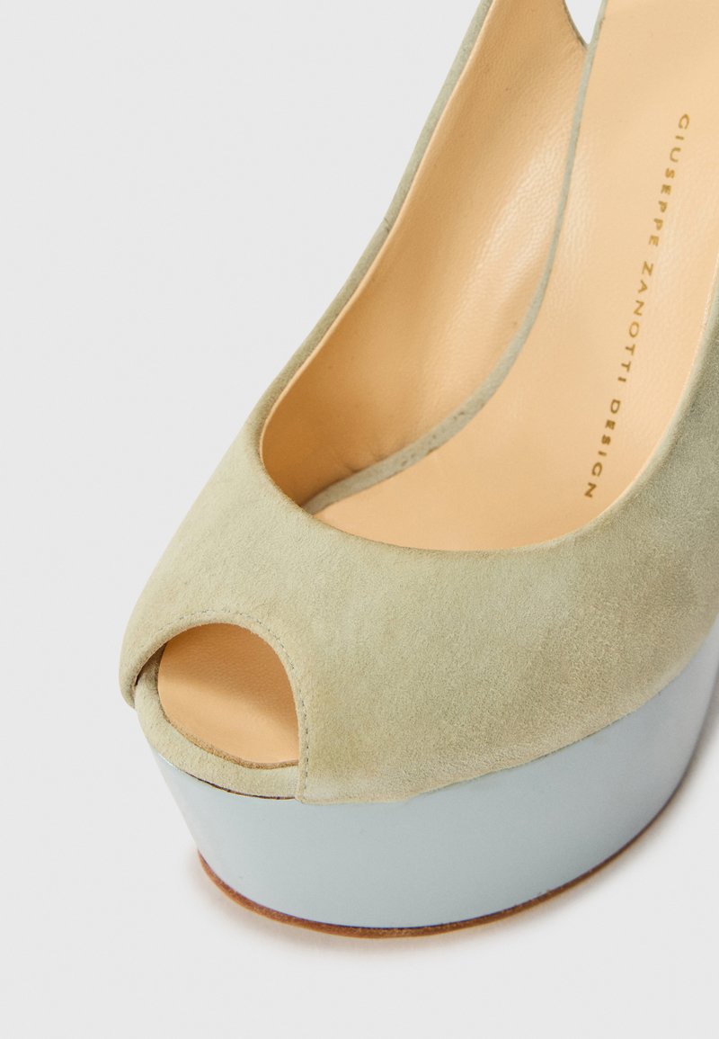 Grüne Wildleder-Pumps mit offenem Zehenbereich, einer hellblauen Plattform und einem glatten Lederinnenfutter.