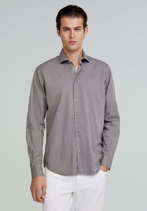 Grijze, lange mouw shirt met een knoopsluiting aan de voorkant, een enkele borstzak en subtiel logo. Glad textuur en klassiek kraagontwerp.