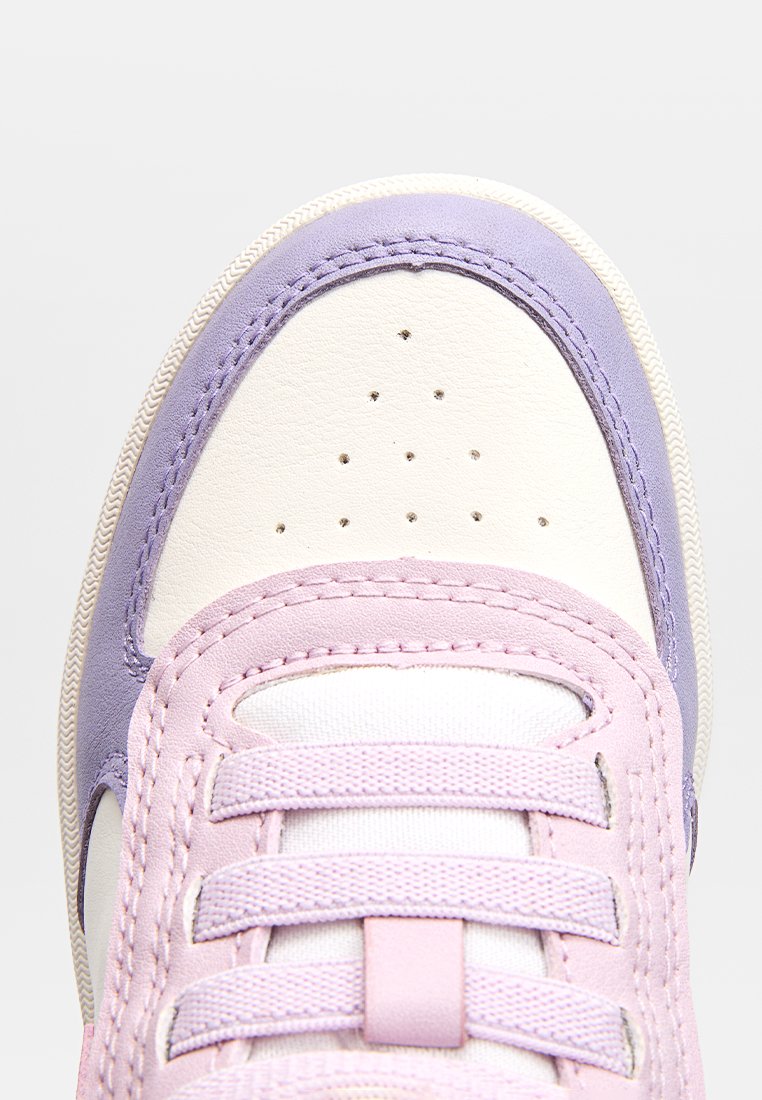Baskets avec un bout en cuir blanc, des accents violet clair et des lacets texturés roses. Des perforations rondes sur le bout améliorent la ventilation.
