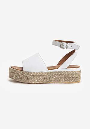 Sandalo platform bianco con suola in juta intrecciata, cinturino alla caviglia con fibbia argentata e ampia fascetta frontale in pelle.