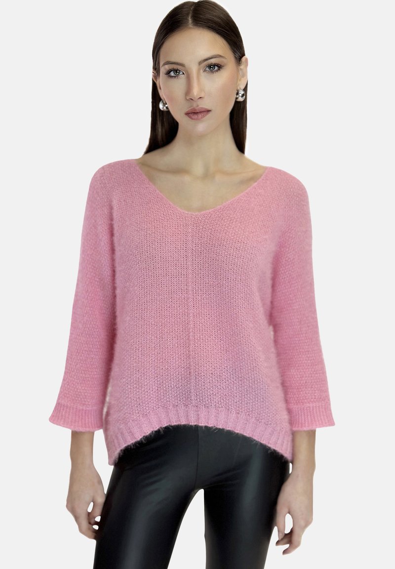 Maglione rosa lavorato a maglia con scollo a V, maniche a 3/4, orlo a costine e vestibilità comoda. Abbinato a leggings neri lucidi ad alta brillantezza.