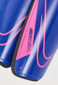 Μπλε κνήμια με γυαλιστερό φινίρισμα, με ροζ λεπτομέρειες και το λογότυπο "Mercurial". Διαμορφωμένο σχήμα με μαύρη επένδυση και ραφές.