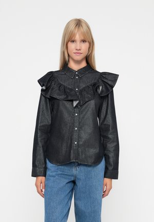 Mustat särk, millel on volangkaelus, nööbid ees ja pikad varrukad. Valmistatud tekstuurilisest kangast, on see keha lähedane disain ja kaardus alläär.