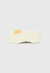 Suola di una sneaker con una texture rigata, prevalentemente bianca con un accento arancione. Il design include linee curve e scanalature per una migliore aderenza.