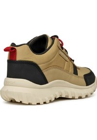 Scarpa sportiva marrone e nera con tomaia sintetica testurizzata, suola in gomma, accenti rossi e una linguetta sul tallone per facilitare l'indossamento.