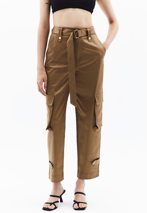 Bruine cargo broeken met riem, zijzakken, tapered pijpen en knoopdetails. Gemaakt van een soepele, lichte stof. Verkorte lengte.