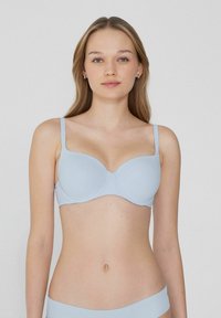 Světle modrá vycpaná podprsenka s nastavitelnými ramínky, hladkým povrchem a bezešvou konstrukcí. Obsahuje zakřivené košíčky pro oporu a má klasický styl.