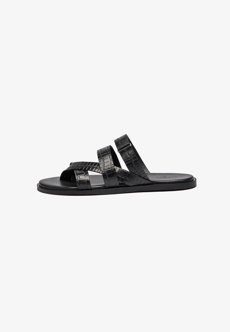 Sandalias negras con tres correas texturizadas y un diseño de punta abierta. El material tiene un patrón de piel de cocodrilo, y la suela es plana y sencilla.