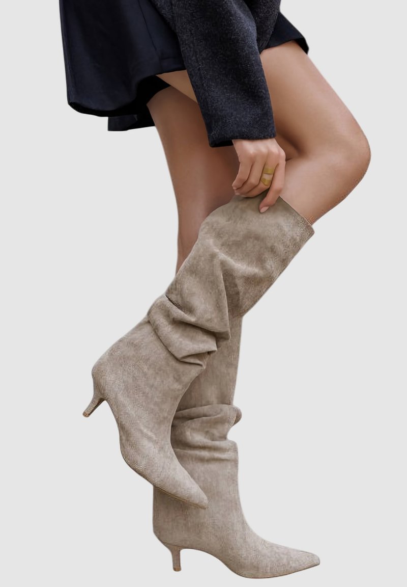 Bottes beige décontractées montant jusqu'aux genoux, à bout pointu, fabriquées en matériau doux semblable au daim et talon stiletto de 7,5 cm.