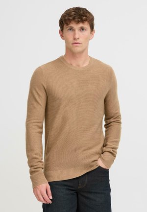 Suéter de punto beige con mangas largas y escote redondo. Presenta puños y dobladillo acanalados, confeccionado en una tela suave y texturizada.
