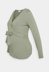 Blusa de maternidade de mangas longas em tecido suave verde-oliva, com um design envolvente, cinto na cintura e um ajuste confortável sobre o abdómen.