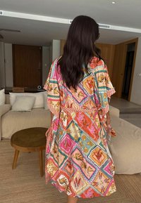 Robe colorat și cu modele în stil kimono, prezentând designuri florale și geometrice. Fabricată dintr-un material ușor, cu o croială lejeră și accente în carouri.