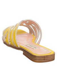 Gele leren slide-sandaal met witte accenten, open ontwerp en een platte zool. Beschikt over een gestructureerde voetbed en een licht gevoerd binnenzool.