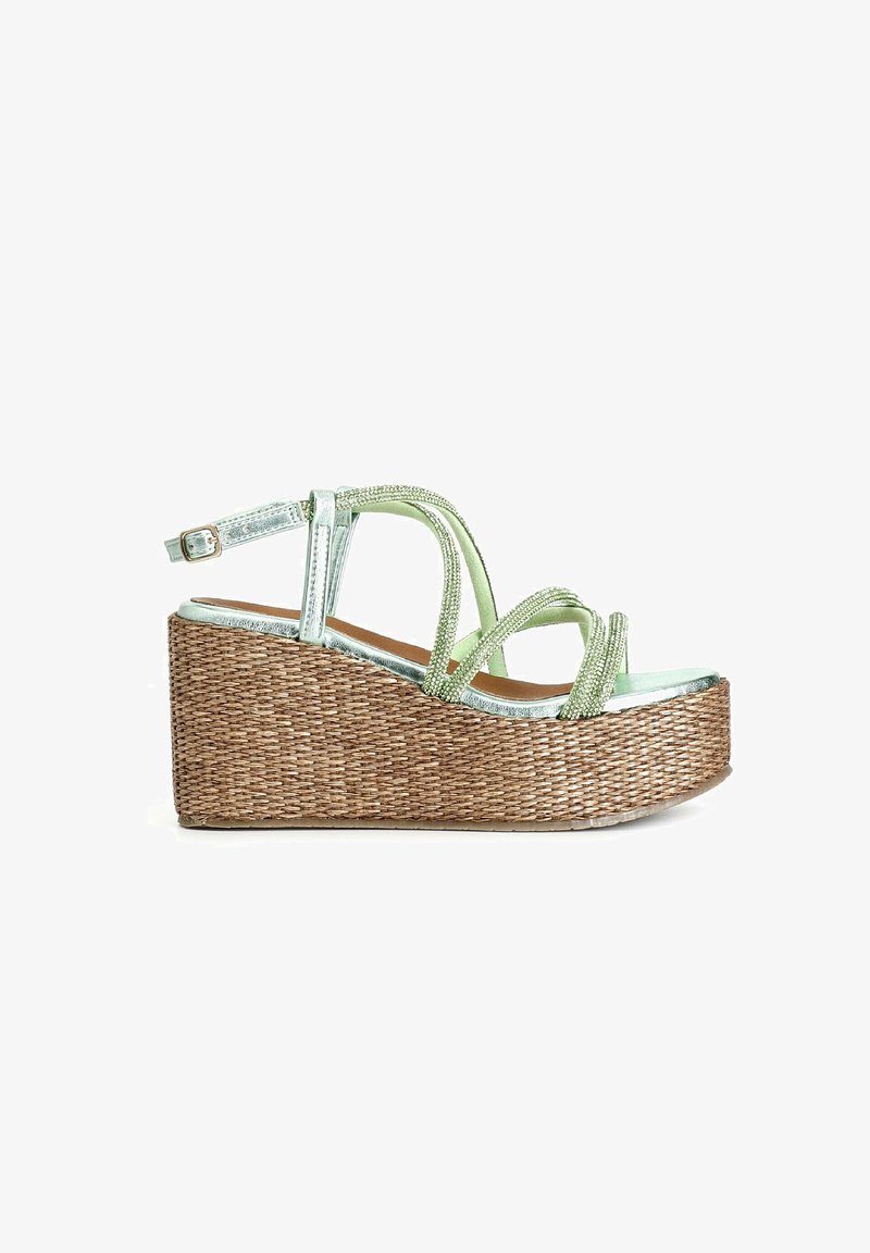 Sandal s klínovým podpatkem, braidsovanou spodní částí z přírodního materiálu, metalickými zelenými pásky a dekorativními korálky. Obsahuje nastavitelné zapínání na kotníku.