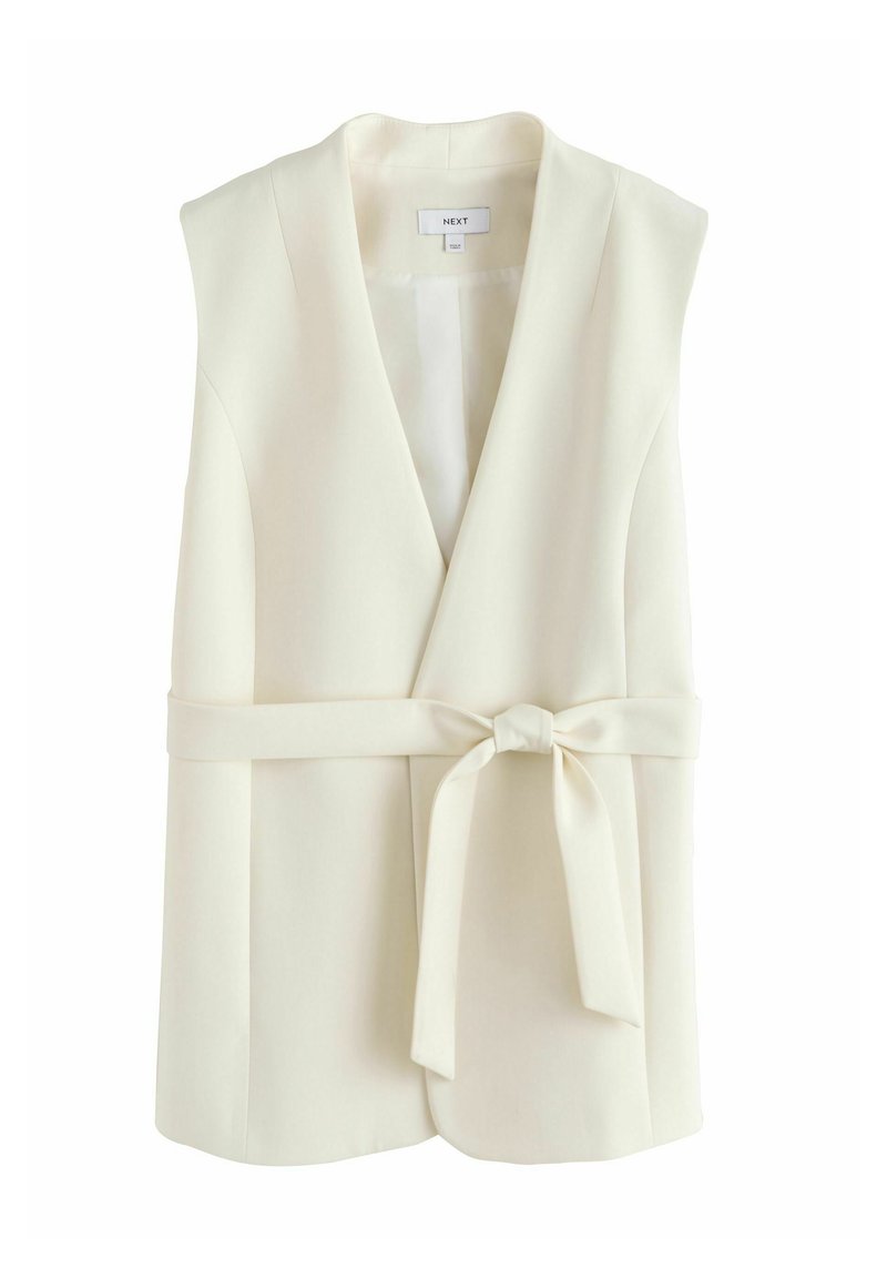 Ärmellose cremefarbene Blazer-Weste mit tiefem V-Ausschnitt und Stoffgürtel, der in einer Schleife in der Taille gebunden ist.