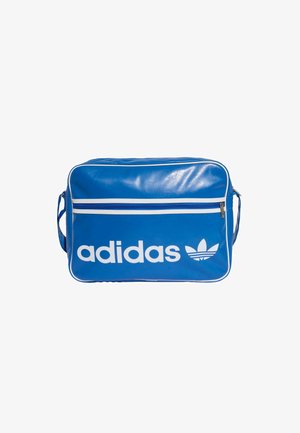 Saco adidas sintético azul com logotipo e detalhes brancos. Apresenta um bolso frontal com fecho zip e um fecho zip azul com acabamento branco.