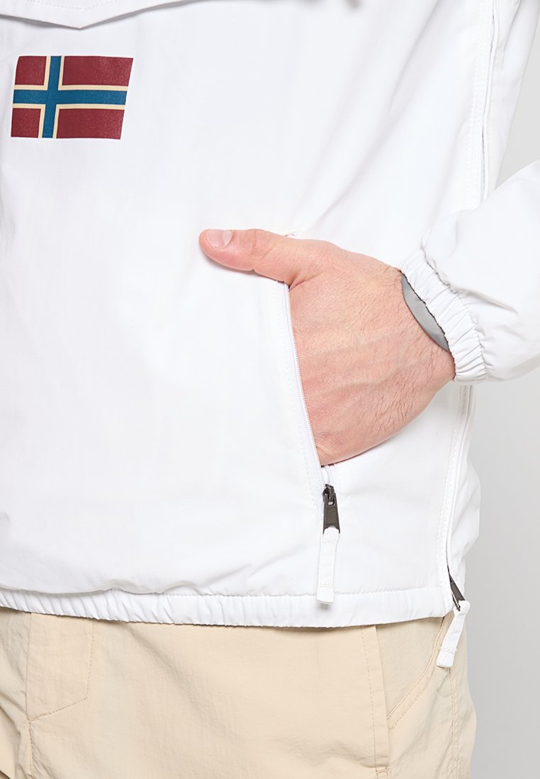Giacca a vento bianca con un patch della bandiera norvegese, polsini elasticizzati e una tasca laterale con zip e dettagli in grigio.