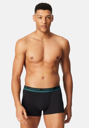 Black boxers with a turquoise "uncover" logo on the waistband, featuring a fitted design and smooth texture.