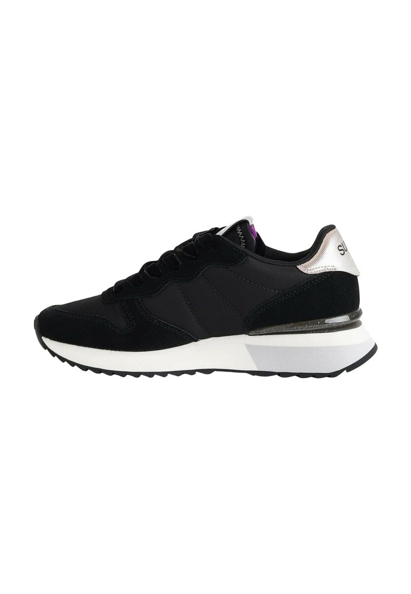Baskets de sport noir et blanc avec une semelle rembourrée, un devant à lacets et un accent de talon argent métallisé.