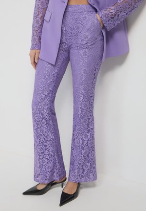 Purple lace flared pants with a textured pattern, paired with a matching fitted blazer featuring lace sleeves and pockets.