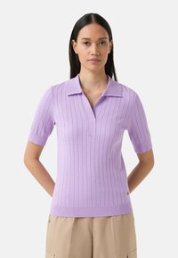 Lilla ribbet polo sweater med korte ærmer og en notch krave, som har en buet kant og en subtil strikstruktur.