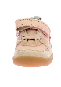 Zapato infantil de color rosa claro con una correa de velcro, diseño de cordones, acentos de ante y una suela de goma beige, con punta redondeada.