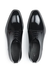 Schwarze patentierte Lederschuhe mit rundem Zehenbereich, Schnürdesign, glatter Textur und dezentem Branding auf der Innensohle.