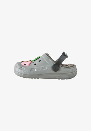 Grauer Slip-On-Clog mit schwarzem verstellbarem Fersenriemen, weichem flauschigem Innenfutter und bunten dekorativen Anhängern oben.