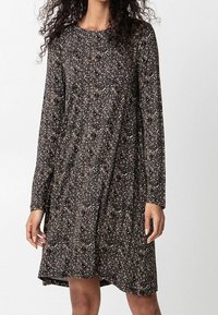 Robe à manches longues en tissu sombre avec un motif floral beige et crème. Silhouette en A avec un col rond et une texture douce.