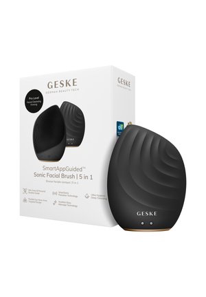 GESKE SmartAppGuided sort sonisk ansigtsbørste med tekstureret overflade, to knapper, ved siden af hvid produktæske med branding og funktioner.