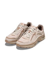 Sneaker sportive beige con una toma superiore in tessuto testurizzato, dettagli in suede, collo imbottito e una suola in gomma spessa con un design a onda.