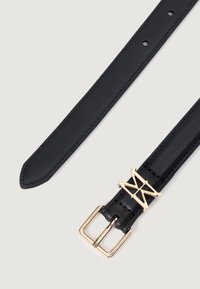 Must lillane vöö kullast geomeetrilise pandlaga. Pandlal on silmapaistev disain ja nahk on sile, kus on nähtavad õmblused.