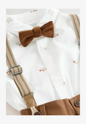 Balts krekls ar lidmašīnu apdrukām, brūns korduroja tauriņš un khaki piekari, ar smilšu krāsas akcentiem un sudraba aparatūru.