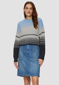 Strickpullover in Blau- und Grautönen mit weiten Ärmeln, kombiniert mit einem Jeansrock mit zwei Vordertaschen und geradem Schnitt.