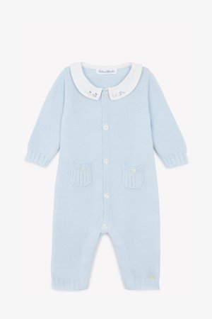 Hellblauer Strick-Overall mit einem weißen Kragen, vorderer Knopfverschluss, zwei strukturierten Taschen und gerippten Bündchen. Dezente bestickte Details am Kragen.
