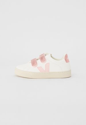 Hvit sneaker med rosa detaljer, utstyrt med en glatt skinnoverdel, borrelåsremmer og en strukturert gummisåle.