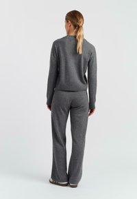 Grijs gebreide trui en bijpassende flared broek, met een geribbelde tailleband en manchetten, een gladde textuur en een comfortabele pasvorm. Eenvoudig design.