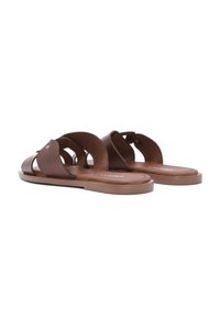 Sandales en cuir marron à glisser avec un design découpé et une semelle plate. Semelle intérieure texturée et semelle extérieure en caoutchouc marron contrastant, détails en métal minimalistes.