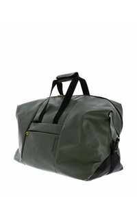 Gran bolsa de lona verde grande, hecha de material impermeable y brillante, con correas negras y un bolsillo frontal con cremallera que tiene un acento amarillo.